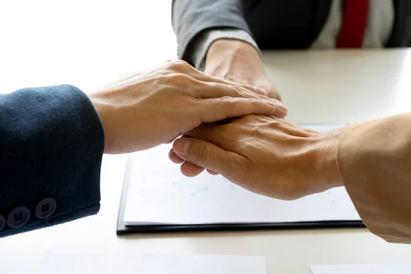 Businessmen stack their hands to show cooperation after a business deal meeting team partnership or as a congratulatory sign.
