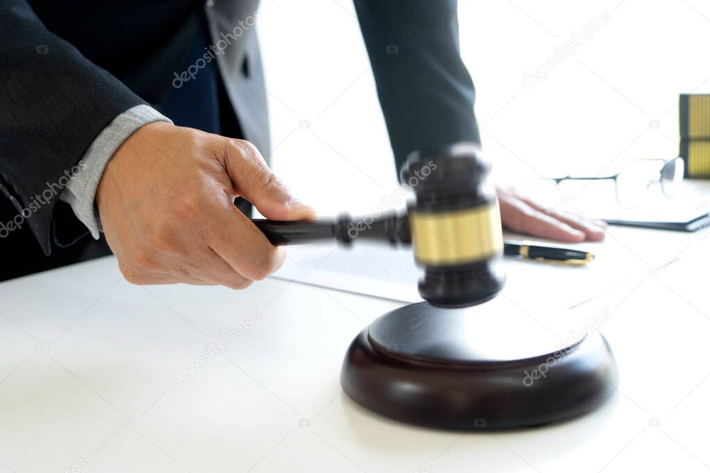 The judge was wave hammering his hand gavel move down to decide the case concept Law firm