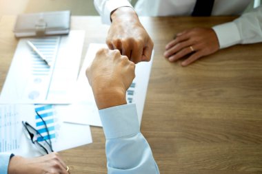 İki işadamı yumruklarını yumruk tokuşturarak iş yapma işini başarıyla yapıyorlar. Takım çalışması üst görünüm daha fazla kopya alanı.