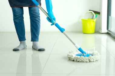 Personel odanın zeminini paspasla temizliyor..