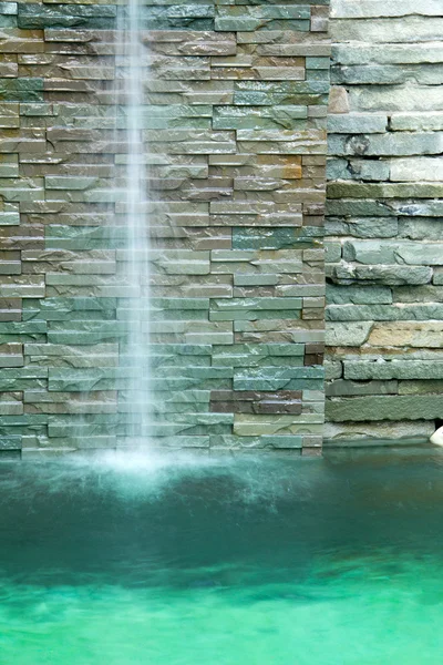 Waterfall decorate in the pool and green water tone — Stock Photo, Image