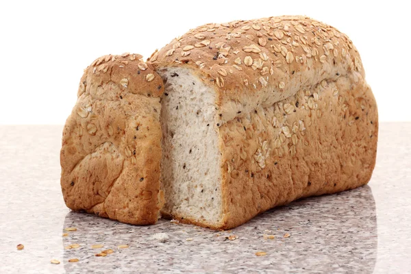 Whole wheat bread sliced on marble table — Stock Photo, Image