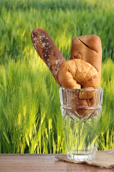 Panadería croissant brad en campo de cebada de vidrio soplado verde — Foto de Stock