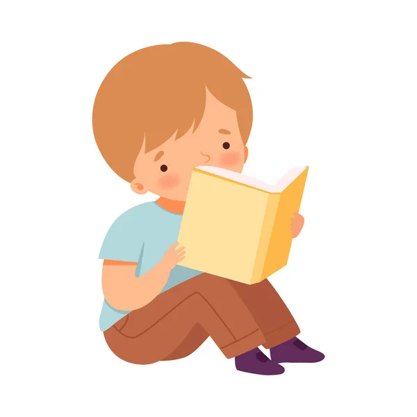 Libro de lectura de niño pequeño, niño lindo sentado en el piso con libro, ventilador de literatura, educación de los niños y concepto de imaginación Ilustración vectorial de estilo de dibujos animados — Vector de stock