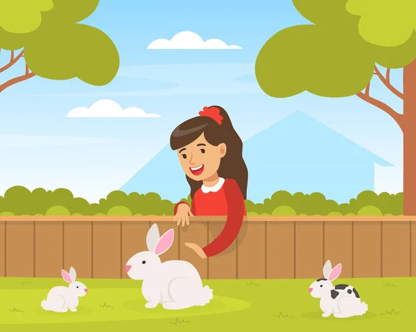 在绿色草坪上与白兔玩耍的可爱女孩，在宠物动物园里与动物互动的可爱女孩 — 图库矢量图片