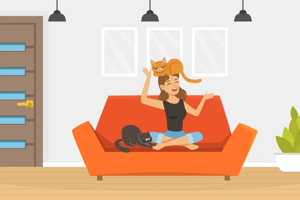 Lachende Tierbesitzerin sitzt auf Sofa und spielt mit Katzen — Stockvektor
