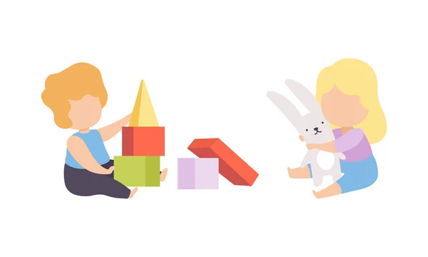 Bébé garçon et fille assis sur le sol et jouant des jouets dans l'ensemble vectoriel de pépinière — Image vectorielle
