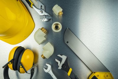 Fırçalanmış alüminyum arka planda boru ve su tesisatı malzemeleri