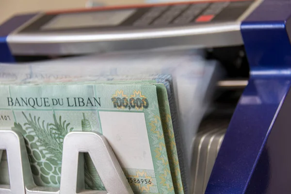 Lebanese Lira (Pound) Currency being counted by a money counting machine.