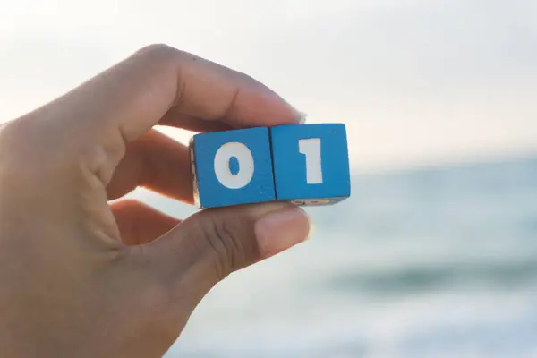 women holds a Number zero and one in hands, sunset, sea background.