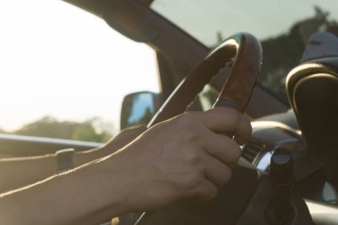 Gün batımlı bir araba süren genç adam..