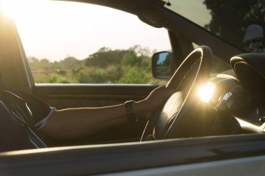 Gün batımında araba süren genç bir adam..