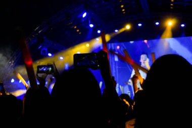İnsanlar akıllı telefonlar ve konserde kalabalık ile fotoğraf konseri veriyor..