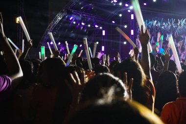 Konserdeki kalabalık siluetleri, elleri havada insanlar..