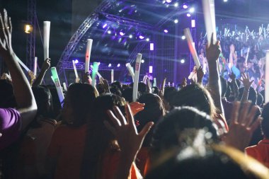 Konserdeki kalabalık siluetleri, elleri havada insanlar..