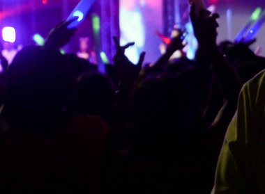 Konserde bulanık kalabalık, parti konsepti, elleri havada insanlar..