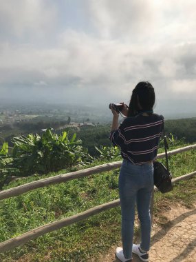 Woman shooting of beautiful view with camera.