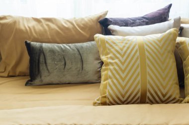 Yatakta çeşitli renkli yastıklar var, kimse yok..