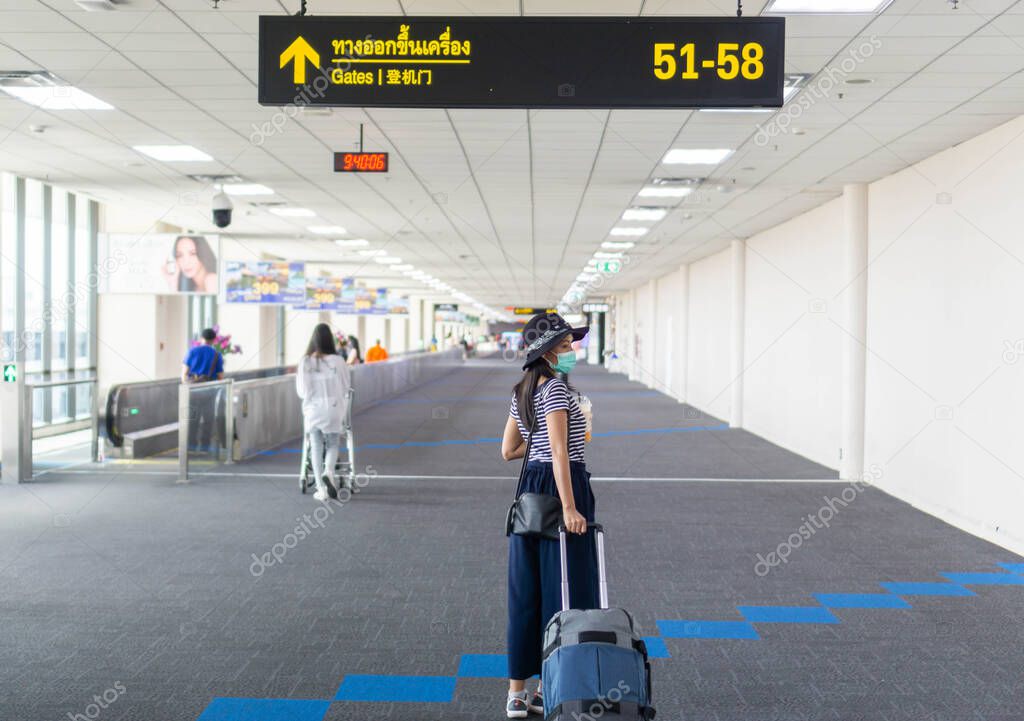 Tourists of Asian women carry luggage in international airports, wearing masks to protect against germs. Especially the corona virus And follow airport standards.