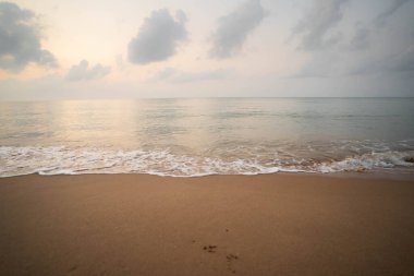 Sabah kumsalda gökyüzü ve deniz dalgaları.