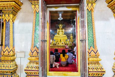 Bangkok, Tayland - 7 Haziran 2020: Asyalı turistler Budistler Wat Paknam Bhasicharoen, Bangkok, Tayland 'daki bir tapınakta altın Buda' ya tapıyorlar.