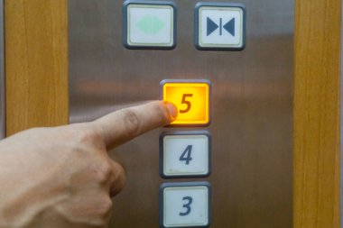 Adamın eli 5 numaralı asansöre basıyor..