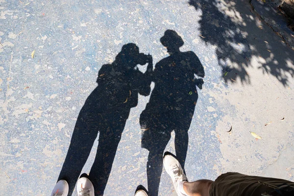 Shadows of women and men, tourists are taking pictures.