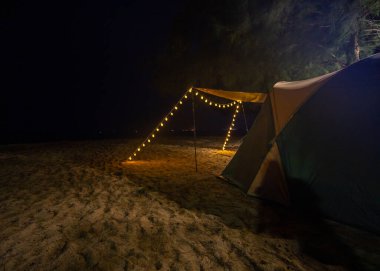 Kumsalda kamp yapmak ve geceleri ışıkları yakmak..