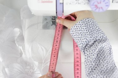 Kadınların elleri terzinin mezurasıyla ölçer. Dikiş işi. 