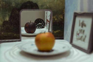 Taze bir elma aynaya çürük bir elma olarak yansıtılır.