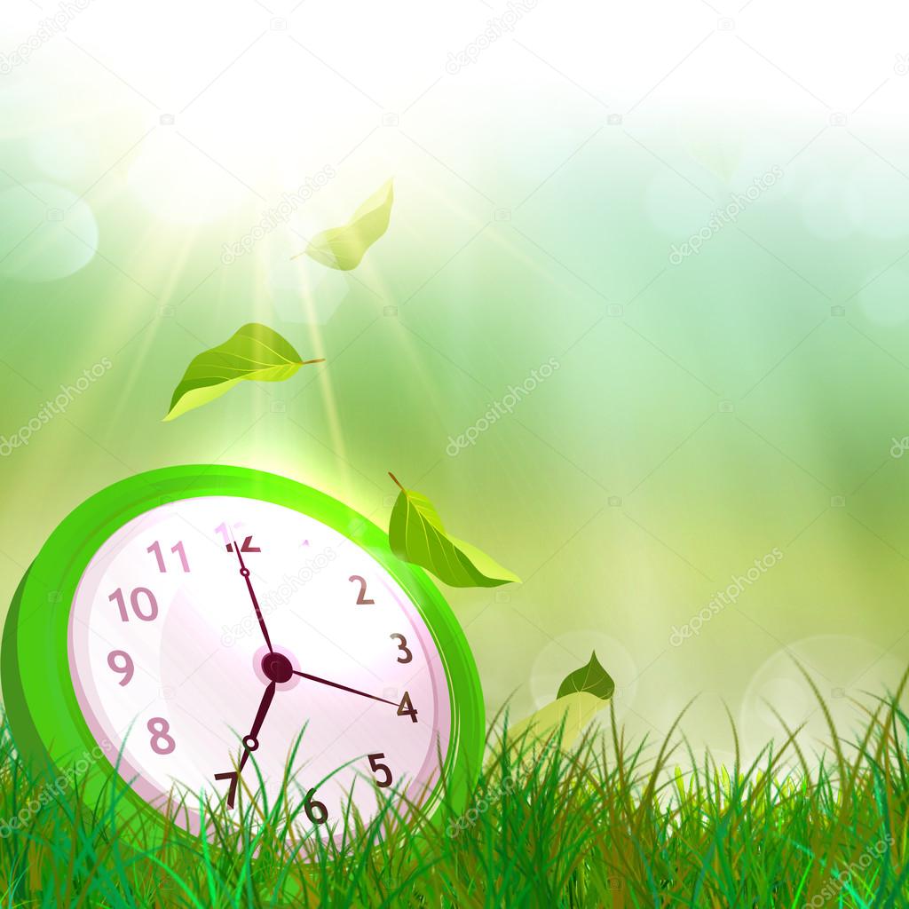 Time concept. Summer time. Alarm clock on the green grass