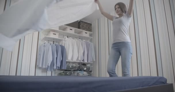 Jonge vrouwen glimlachend en maken van bed ongesorteerde — Stockvideo