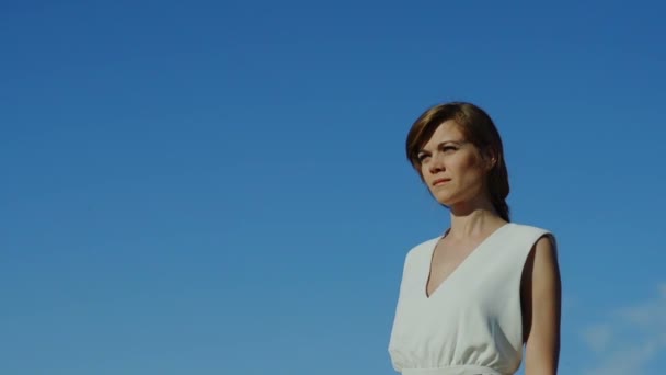 Потрясающая женщина в платье ходит по голубому небу — стоковое видео