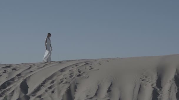 Mujeres en vestido blanco caminando sobre duna de arena sin graduar — Vídeos de Stock