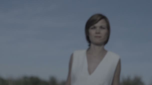 Nadenkend vrouw in witte jurk wandelen buiten flat — Stockvideo