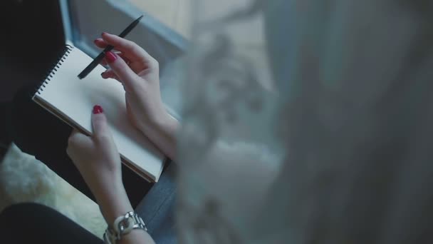 Женщина думает, что писать с блокнотом и карандашом — стоковое видео