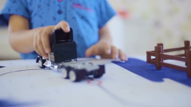 Маленький хлопчик тримає і водить іграшкову вантажівку — стокове відео
