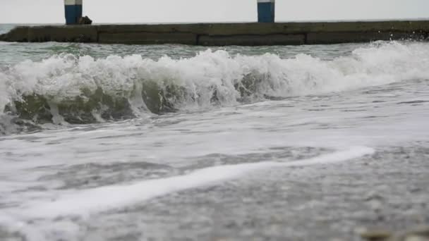 Foamy sea waves spreading over the beach in cloudy wather — Stock Video