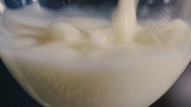 Hindistan cevizi sütü bardağa dökülür.