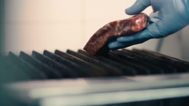Шеф-повар кладет мясной стейк на гриль — стоковое видео
