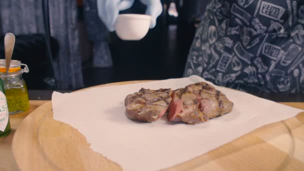 Шеф-повар кладет соус, помидоры и розмарин в стейк — стоковое видео