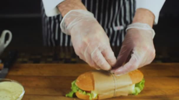 Le chef attache un enveloppeur pour un grand sandwich — Video