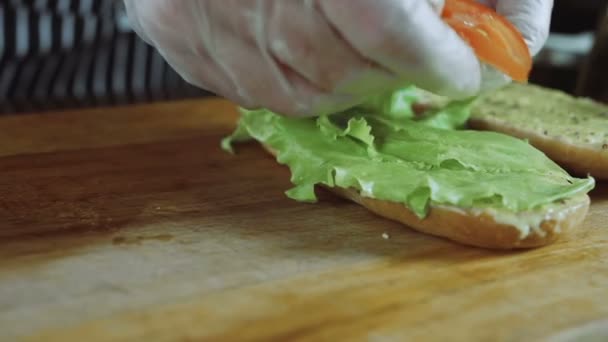 Chef corta tomates no sanduíche — Vídeo de Stock