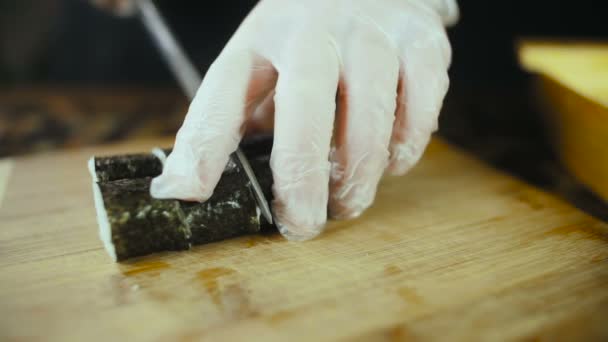 Шеф-повар режет суши на деревянной доске — стоковое видео