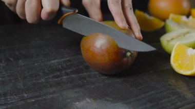 Şef Mango koyu ahşap masanın üstüne kesmek.