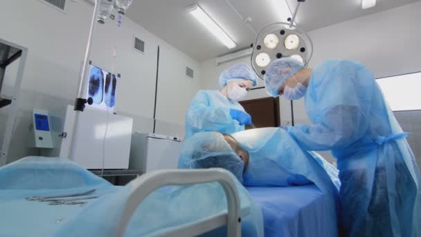 Хірург і медсестра на роботі в операційній — стокове відео