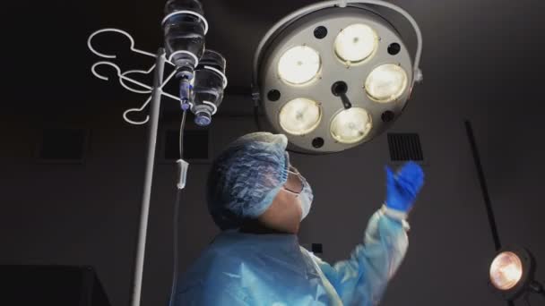 Хирург контролирует хирургическую лампу — стоковое видео