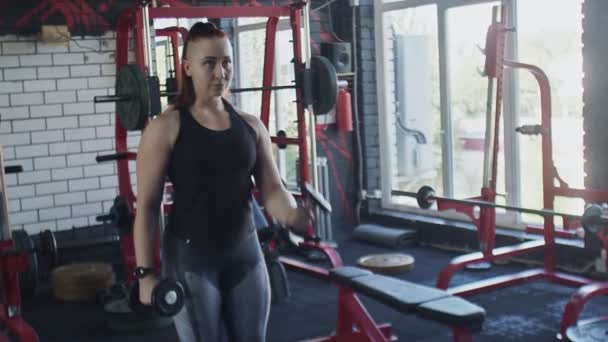 Muscular mujer hace Curl con mancuernas de ejercicio en el gimnasio — Vídeo de stock