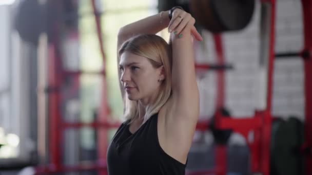Detailní záběr fit blondýny ženy dělá strečink cvičení po tréninku v tělocvičně — Stock video