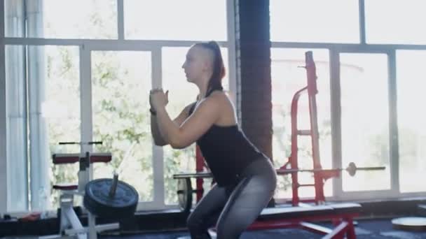 Jonge gespierde vrouw doet squats in de sportschool — Stockvideo